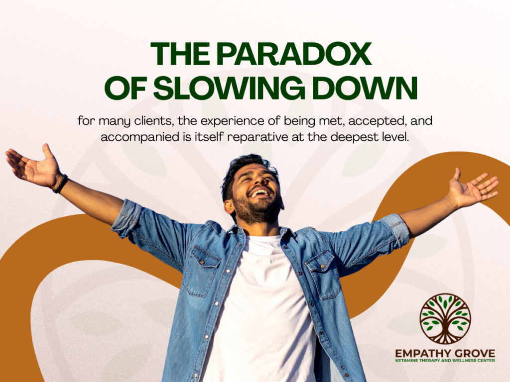 A joyful man stands outdoors with arms outstretched under the text The Paradox of Slowing Down and a quote about acceptance, highlighting the journey toward healing through ketamine therapy. The Empathy Grove Ketamine Therapy and Wellness Center logo appears at the bottom right.