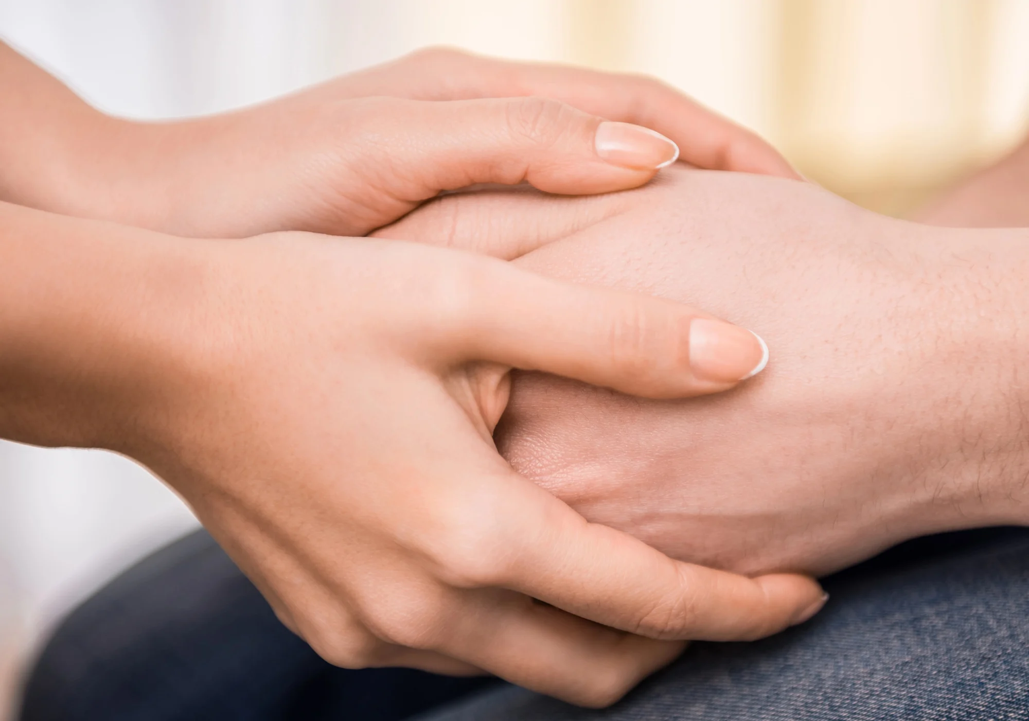 Two hands gently holding another person’s hand, conveying comfort and support—a visual reflection of the compassionate care offered through Ketamine Therapy in Tualatin. The background is softly blurred, keeping the focus on this caring gesture.